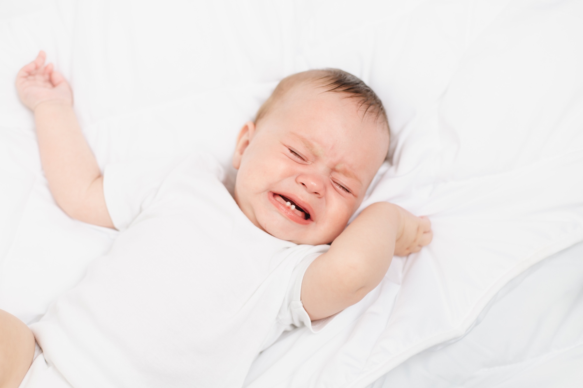 The baby is crying in his crib . The baby 's teeth are teething . Colic in babies . Hungry baby .